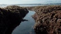 ÃÂ Blue sea water with bare rocks and green reefs